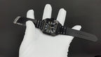 Cartier watch on black leather strap with Roman numeral dial, laid across white glove.