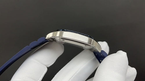 Silver wristwatch case side with blue leather strap, shown in close profile
