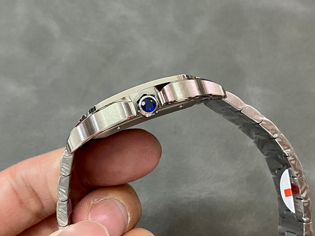 Silver Cartier watch bezel with blue gemstone accent