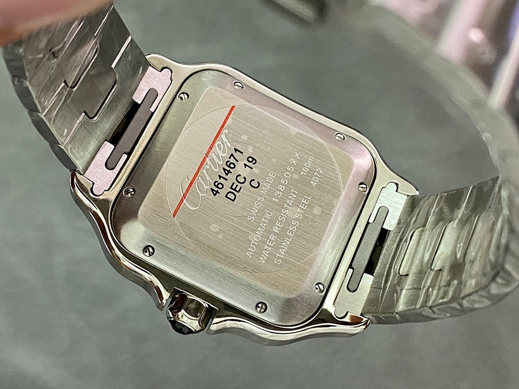 Wristwatch case back with engraved markings and steel clasp, viewed from above