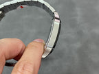 Wristwatch case side view with steel bracelet links and black dial bezel edge