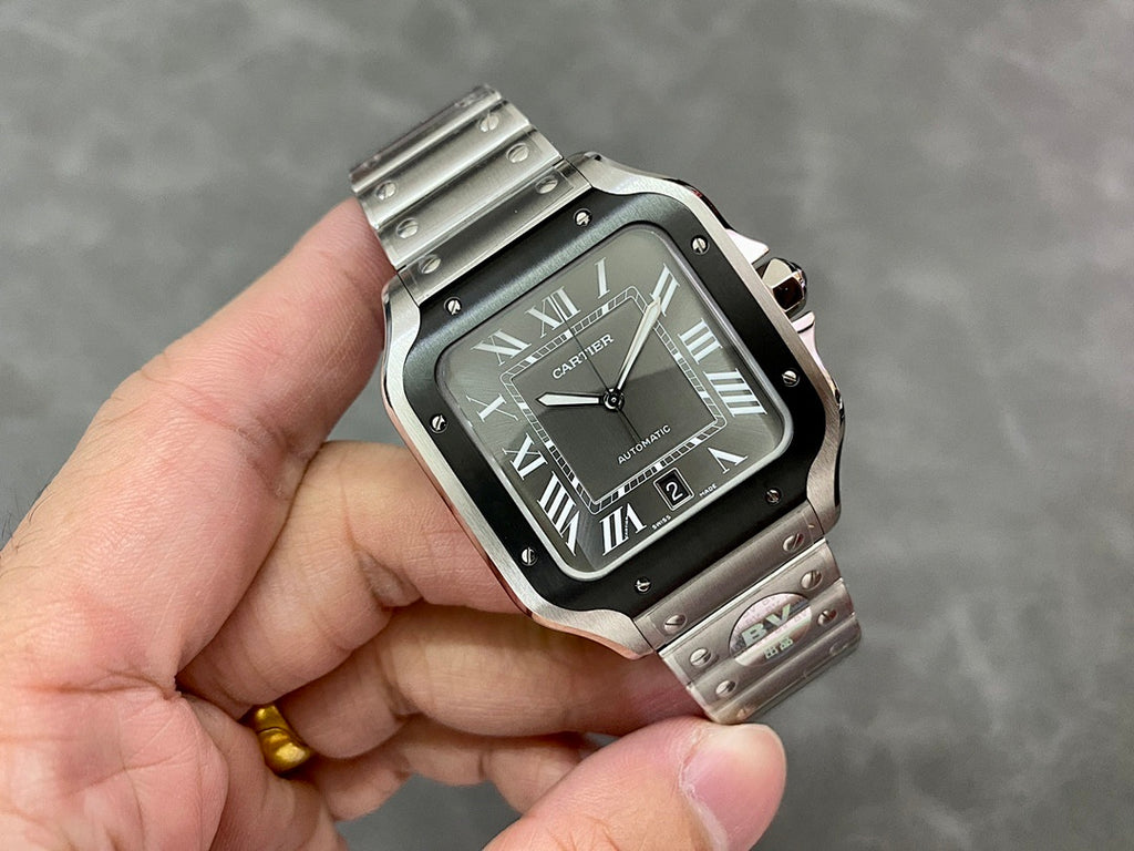 Wristwatch with black dial, Roman numerals, and steel bracelet, held at angle