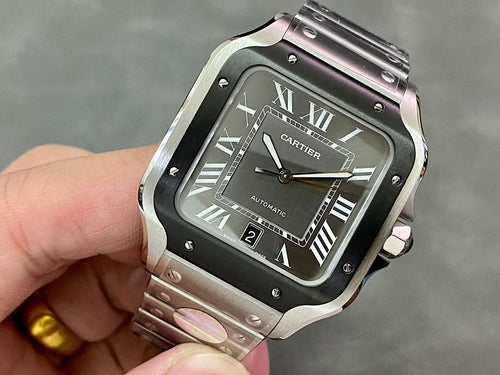 Wristwatch with black square dial, Roman numerals, and steel bracelet, held in hand