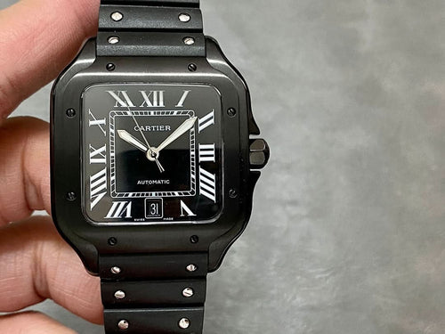 Cartier watch front view with black dial, Roman numerals, date window, and black strap.