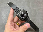 Cartier watch on black strap with Roman numerals dial and visible metal clasp.