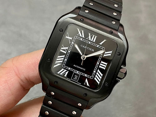 Cartier watch with black dial, Roman numerals, date window, and black rubber strap.