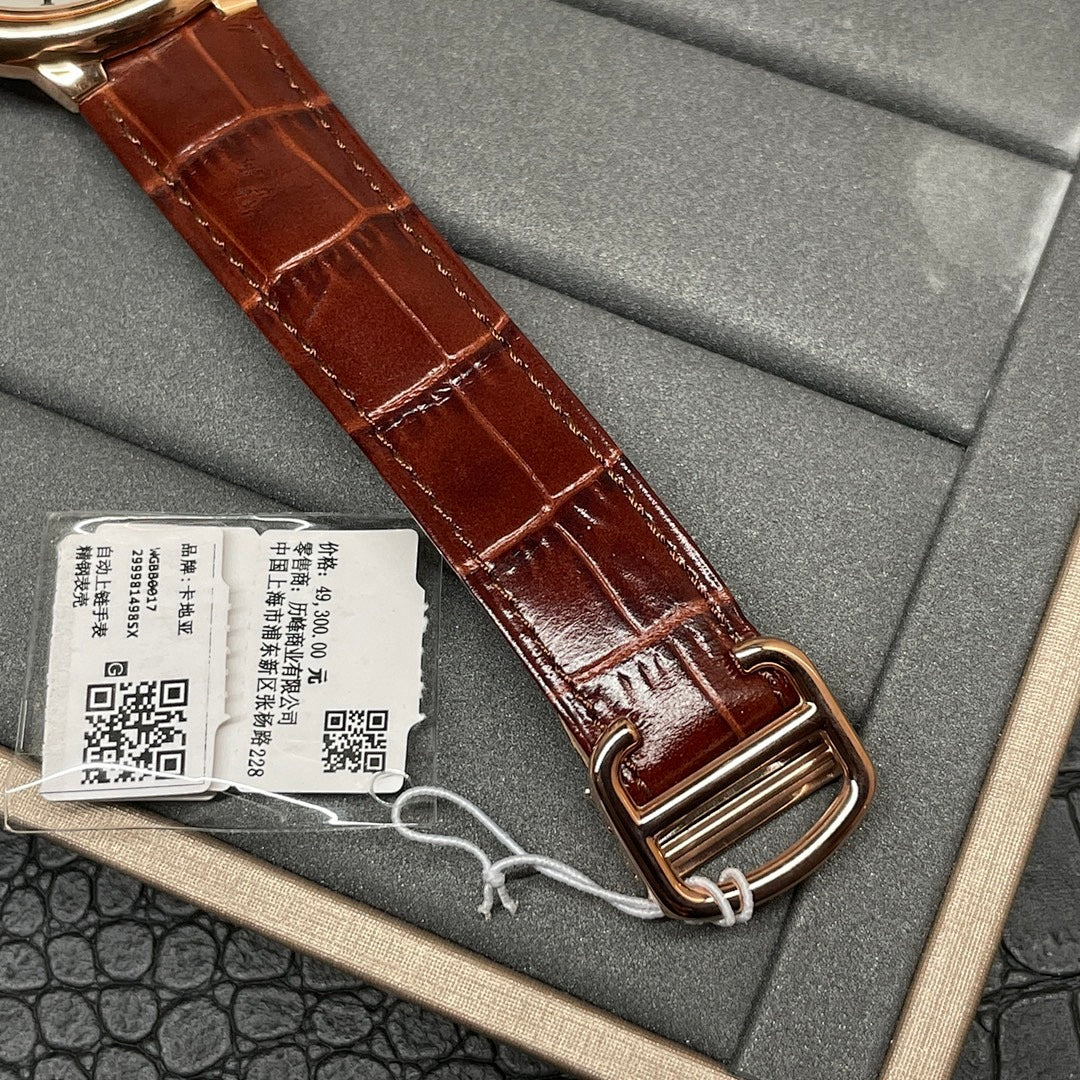 Cartier wristwatch close-up showing brown leather strap and rose-gold buckle in box
