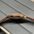 Cartier wristwatch side view with polished rose-gold case and brown leather strap