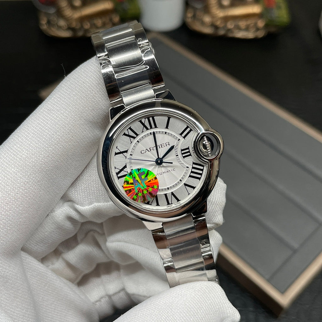 Cartier watch with silver bracelet, round white dial and Roman numerals, front close-up