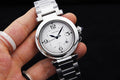 Cartier watch with white dial and black numerals, silver bracelet, held in hand