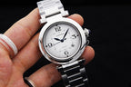 Cartier watch with white dial and black numerals, silver bracelet, held in hand