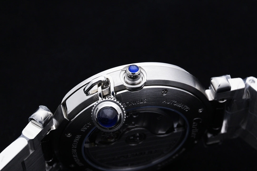 Cartier watch top view with crown and two blue accents on silver case