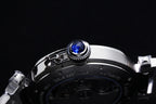 Cartier watch close-up of crown with blue gemstone on dark dial bezel
