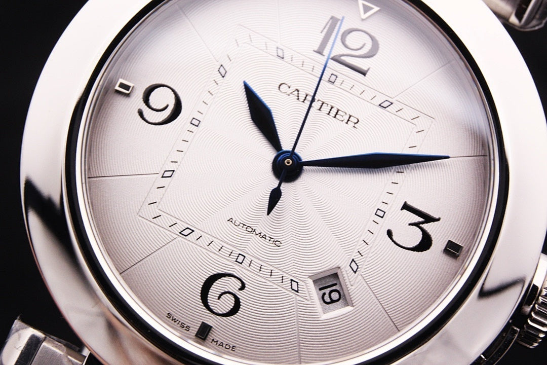 Cartier watch dial close-up with blue hands, Arabic numerals, and patterned face
