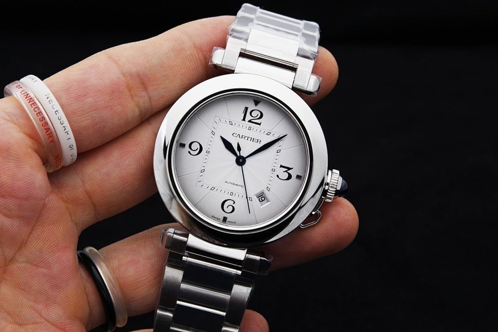 Cartier watch on wrist with white dial and silver link bracelet, held by hand
