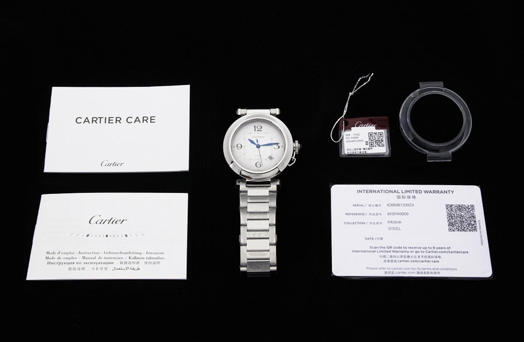 Cartier watch set with booklet, warranty card, and metal bracelet, accessories laid out