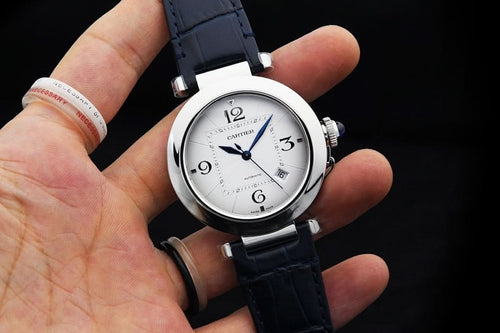 Cartier wristwatch with silver case and dark blue leather strap, round white dial