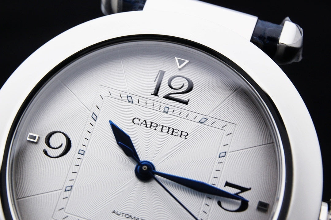 Cartier wristwatch face close-up with white dial and blue hour and minute hands