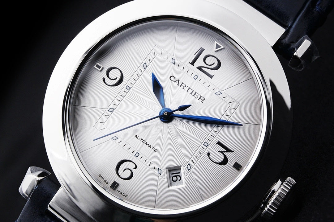 Cartier wristwatch face close-up with white dial, blue hands and date markers