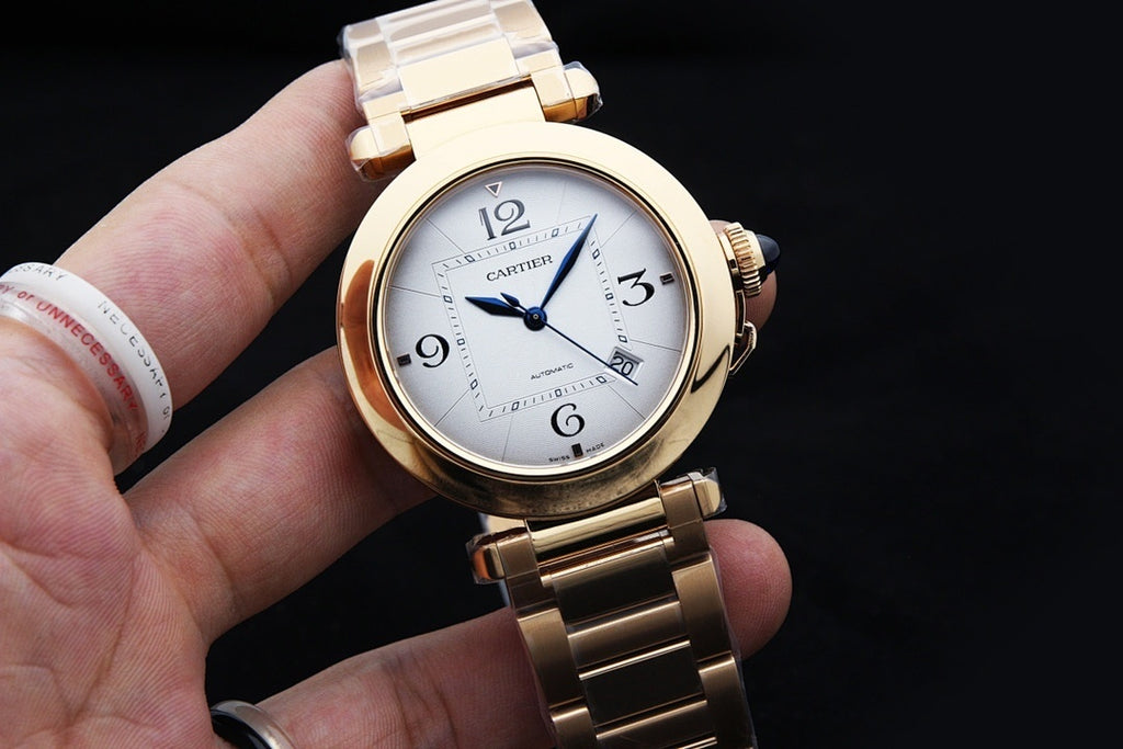 Gold-tone Cartier watch with white dial, blue hands, Roman numerals, link bracelet