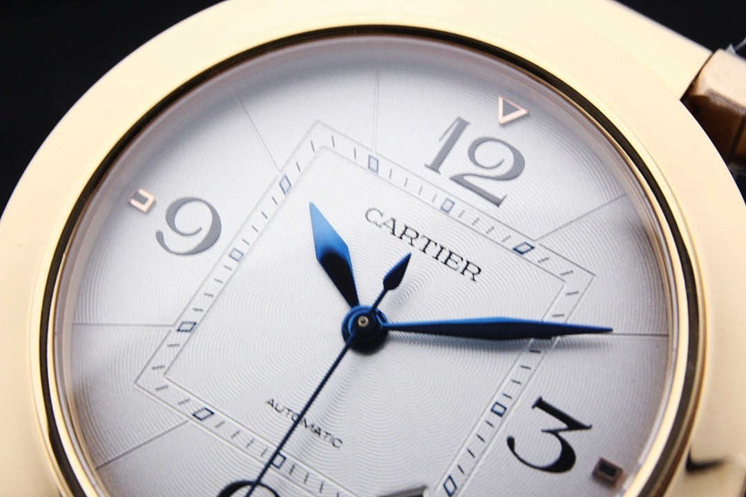 Gold-tone Cartier watch face close-up with white dial and blue hour/minute hands
