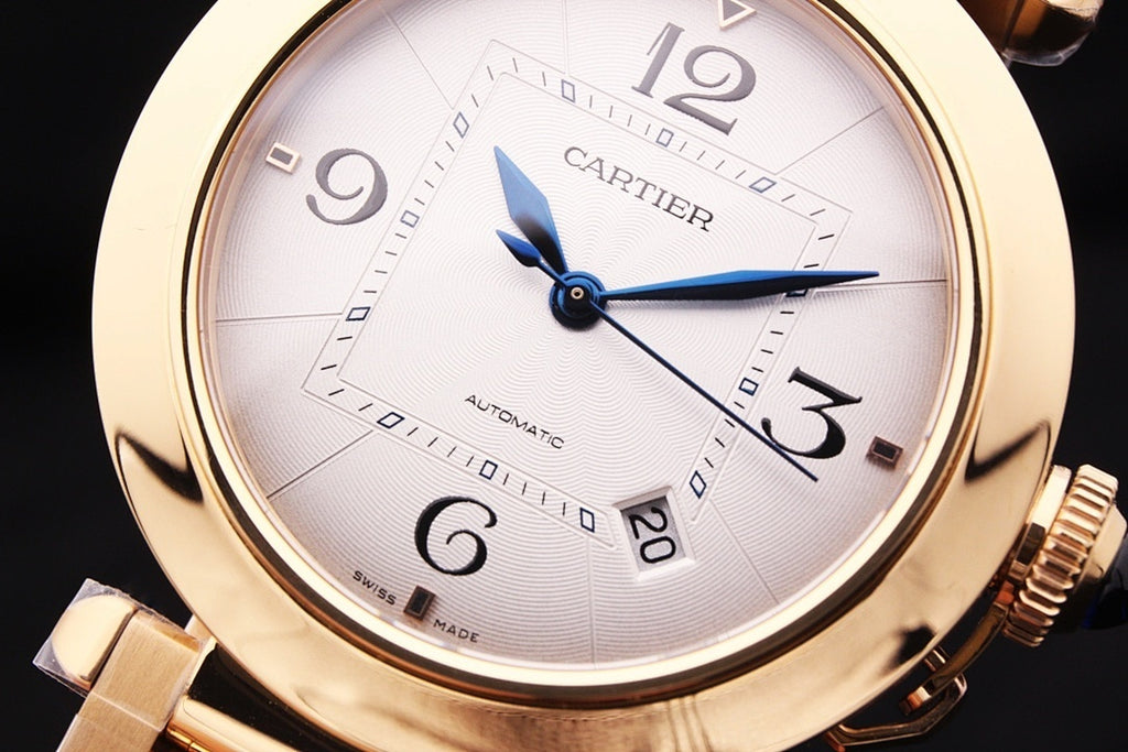 Gold-tone Cartier watch dial with Roman numerals and blue automatic hands