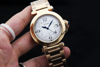 Gold-tone Cartier watch with white dial, blue hands, Roman numbers, bracelet view