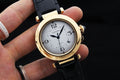 Cartier watch with white dial, gold-tone case, black leather strap and crown