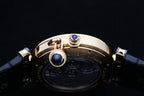Cartier watch crown and blue accents on gold-tone case with dark leather strap