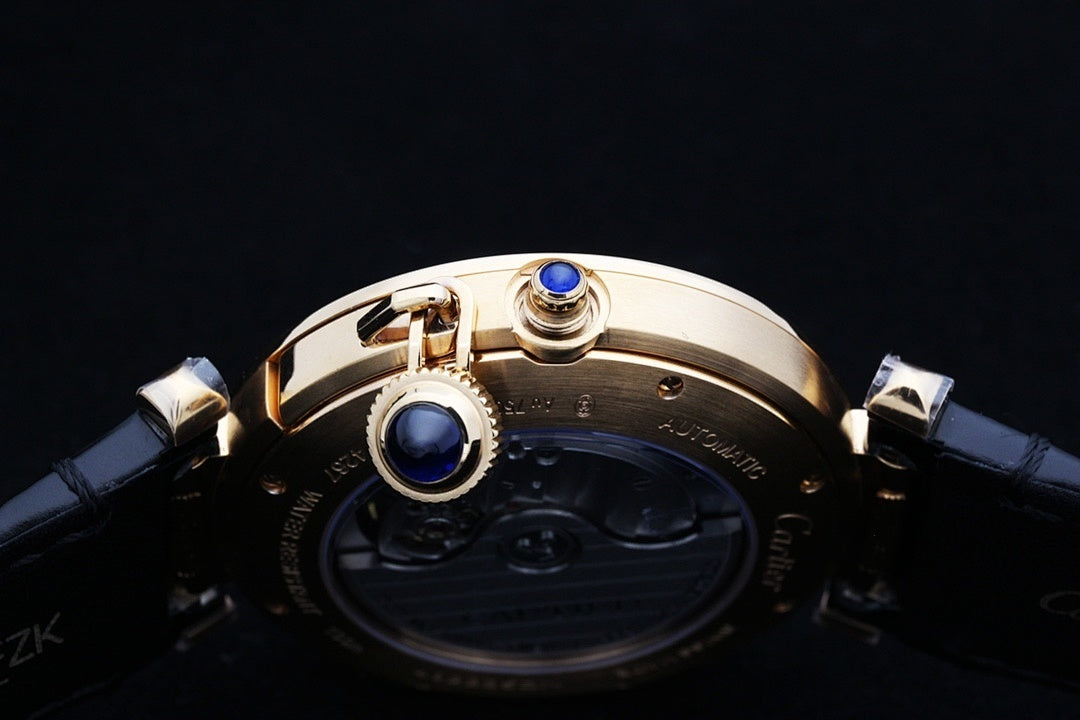 Cartier watch crown and blue accents on gold-tone case with dark leather strap