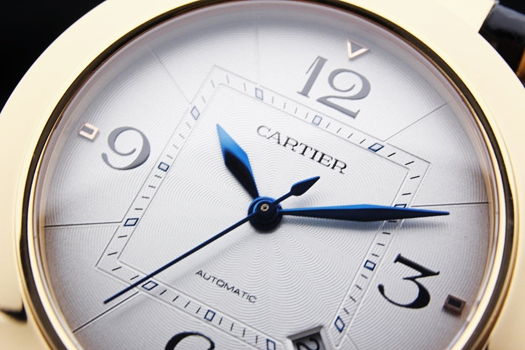 Cartier watch dial close-up with blue hands and gold-tone markers
