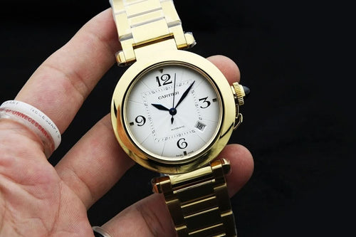 Cartier gold-tone watch with white dial and blue hands, on a link bracelet.