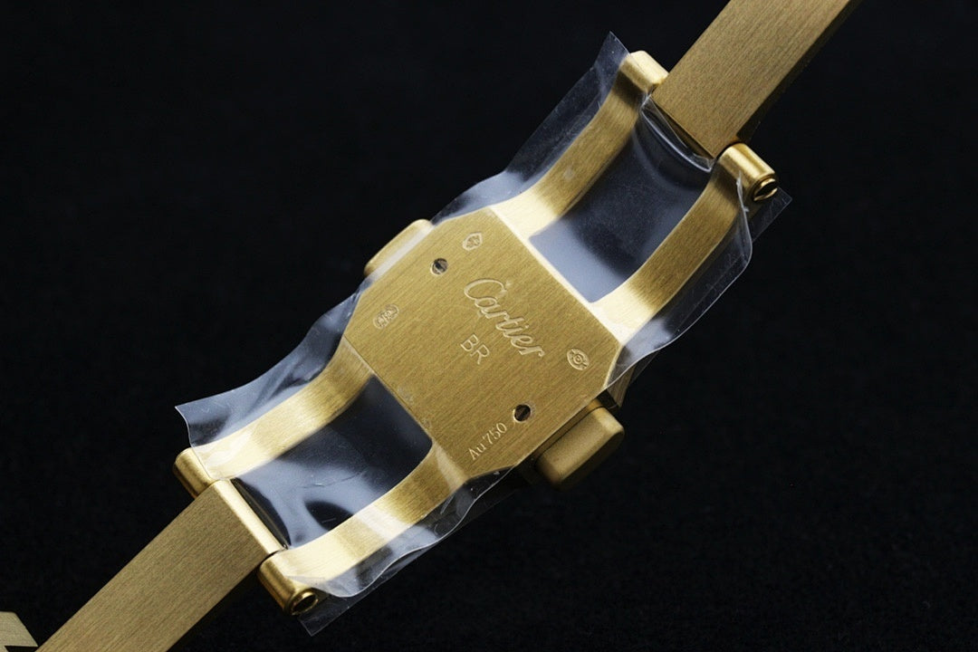 Cartier gold-tone watch clasp with engraved details on the bracelet.
