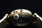 Cartier gold-tone watch with crown and bezel detail featuring a blue gemstone.