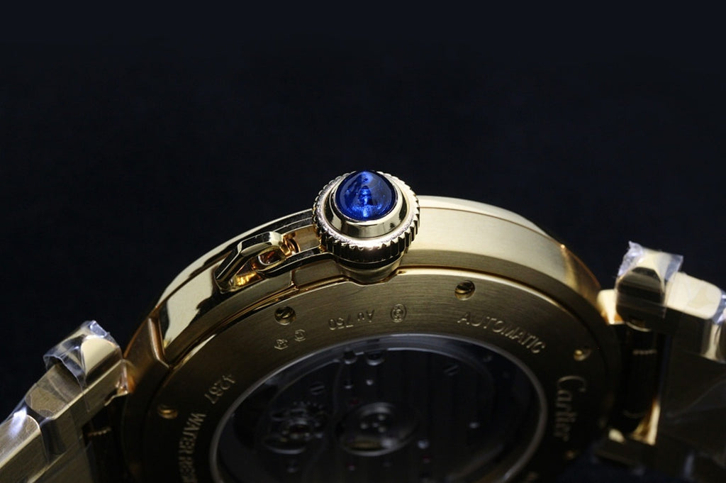 Cartier gold-tone watch bezel with blue gemstone setting and case back view.