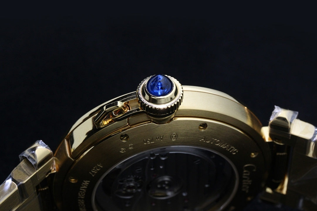 Cartier gold-tone watch bezel with blue gemstone setting and case back view.