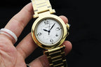 Cartier gold-tone wristwatch with white dial, blue hands, and gold link bracelet.