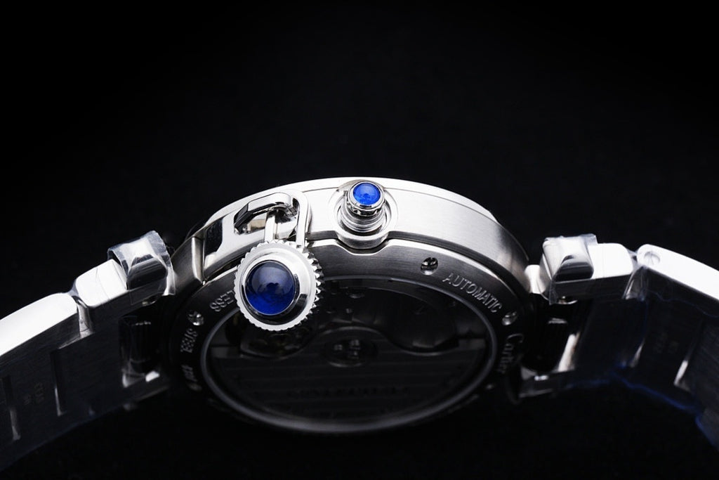 Cartier watch caseback with visible blue screw caps and stainless steel bracelet links.