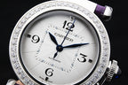 Cartier watch dial close-up with blue center hand, jeweled silver bezel