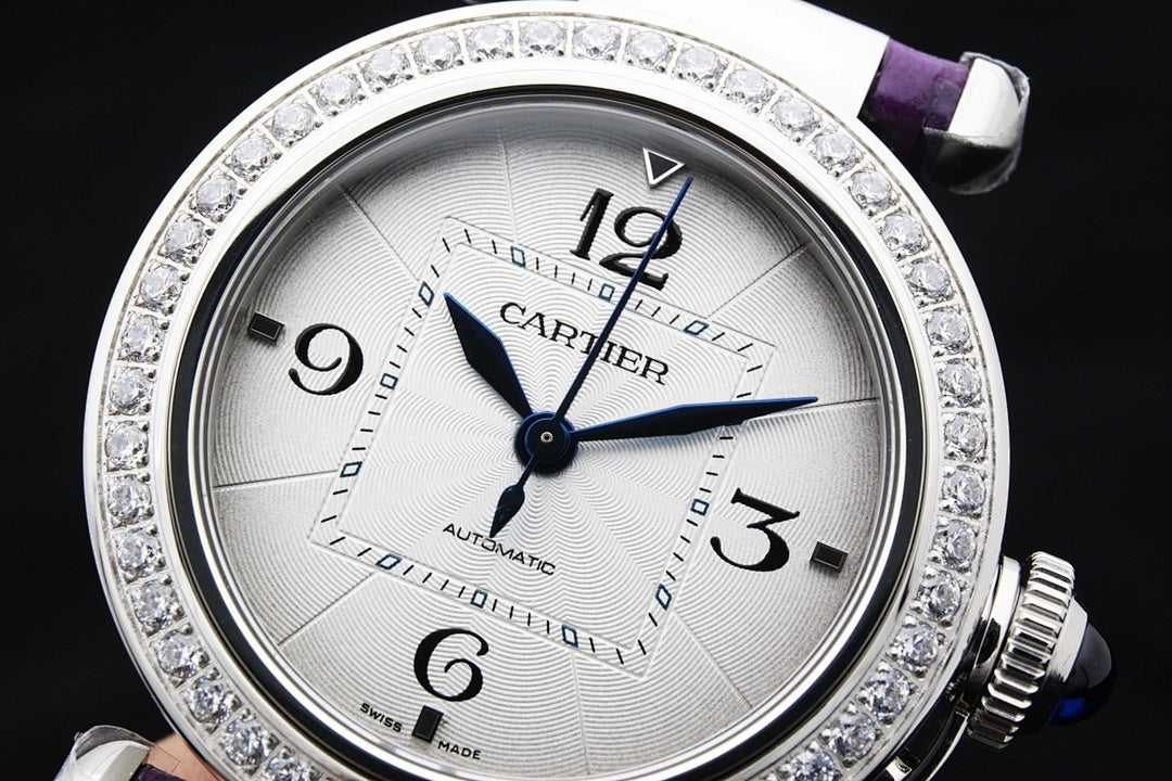 Cartier watch dial close-up with blue center hand, jeweled silver bezel