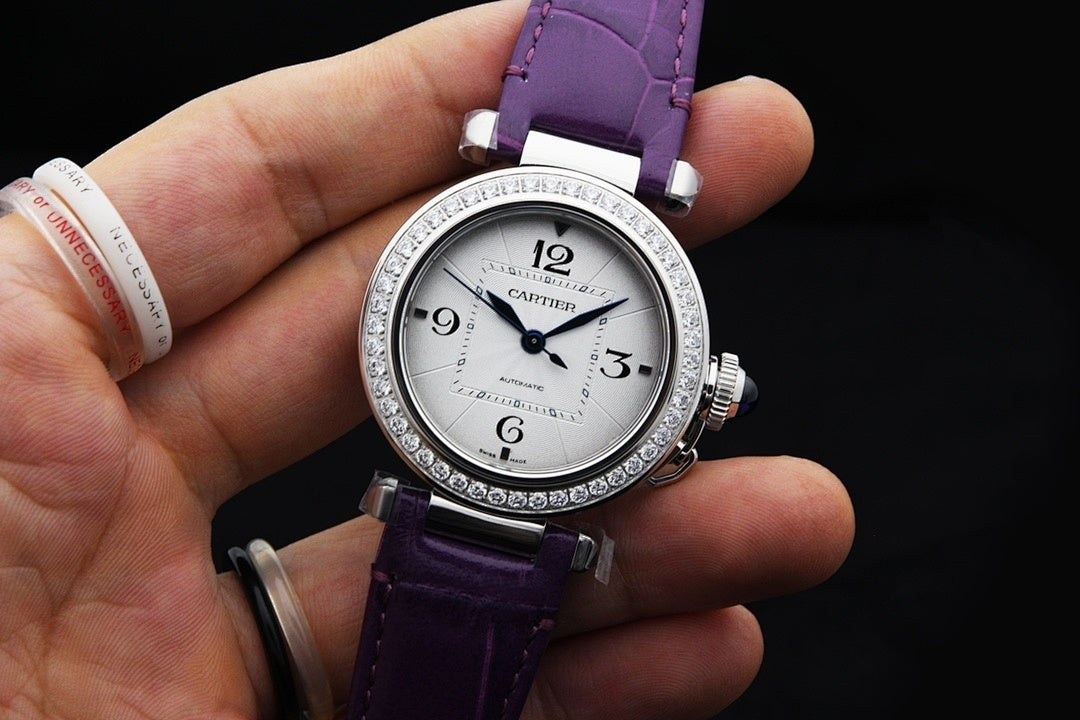 Cartier watch on purple leather strap, silver jeweled bezel, white dial close-up