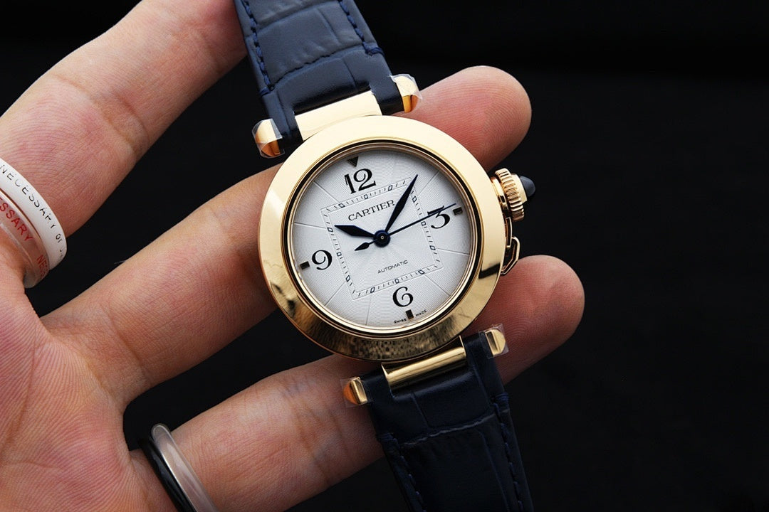 Cartier watch with blue leather strap, gold case, white dial, Roman numerals