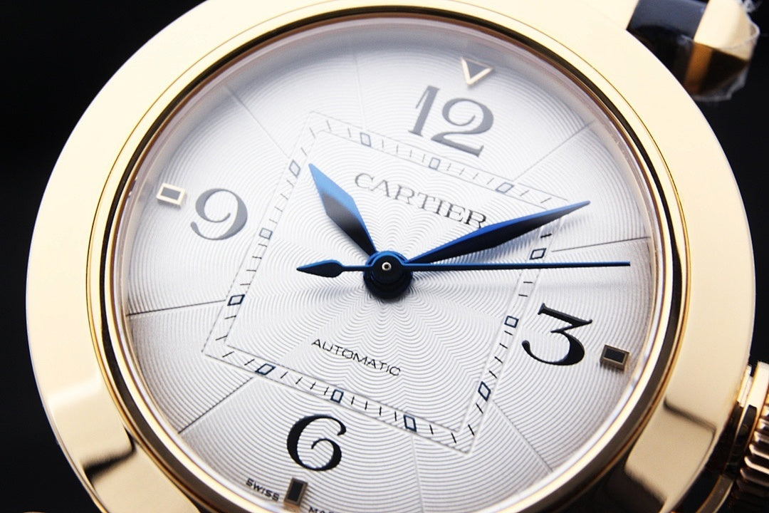 Cartier watch close-up of white dial, blue hands, gold bezel, Roman numerals