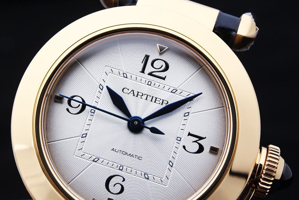 Cartier watch face close-up with white dial, blue hands and Roman numerals