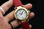 Cartier watch with gold-tone case, white dial, red leather strap, two-hand design