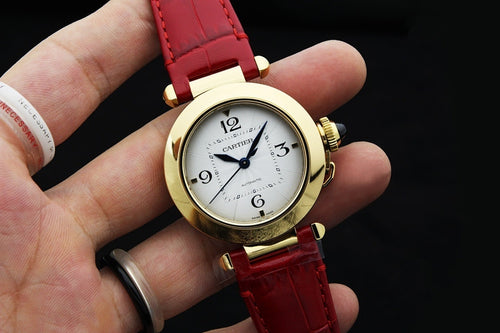 Cartier watch with gold-tone case, white dial, red leather strap, two-hand design