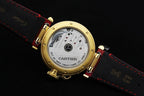 Cartier watch caseback with visible movement, red leather strap, gold-tone bezel