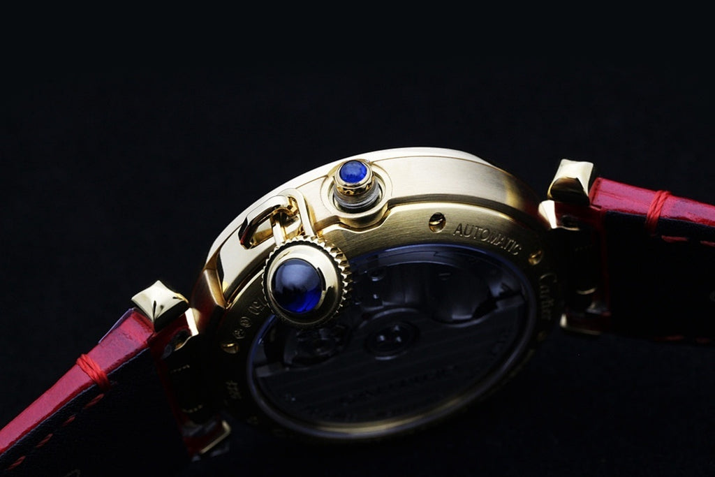 Cartier watch crown with blue jewel detail and red leather strap