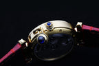 Cartier watch crown with blue jewel detail and red leather strap