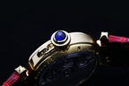 Cartier watch crown and blue jewel detail with red leather strap